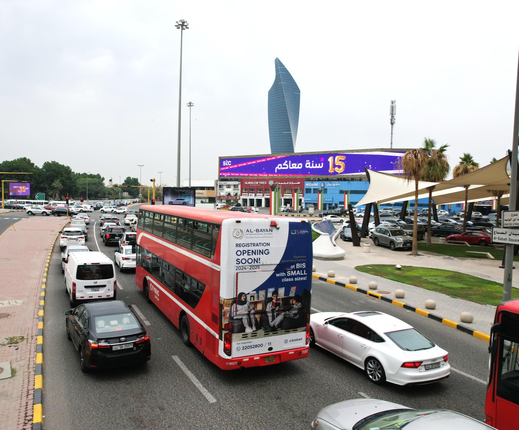 Double-decker bus rear billboard in traffic, Kuwait City
